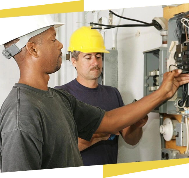 Two men in hard hats working on a machine.